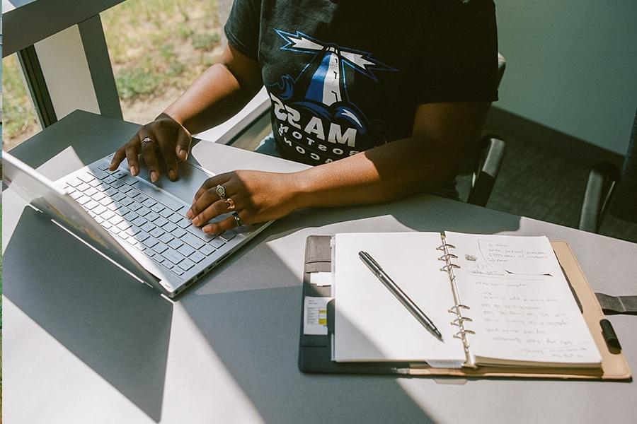 Student on a laptop taking notes