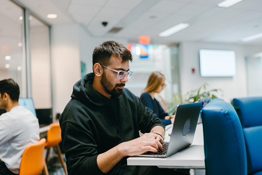 student on laptop in One Stop office